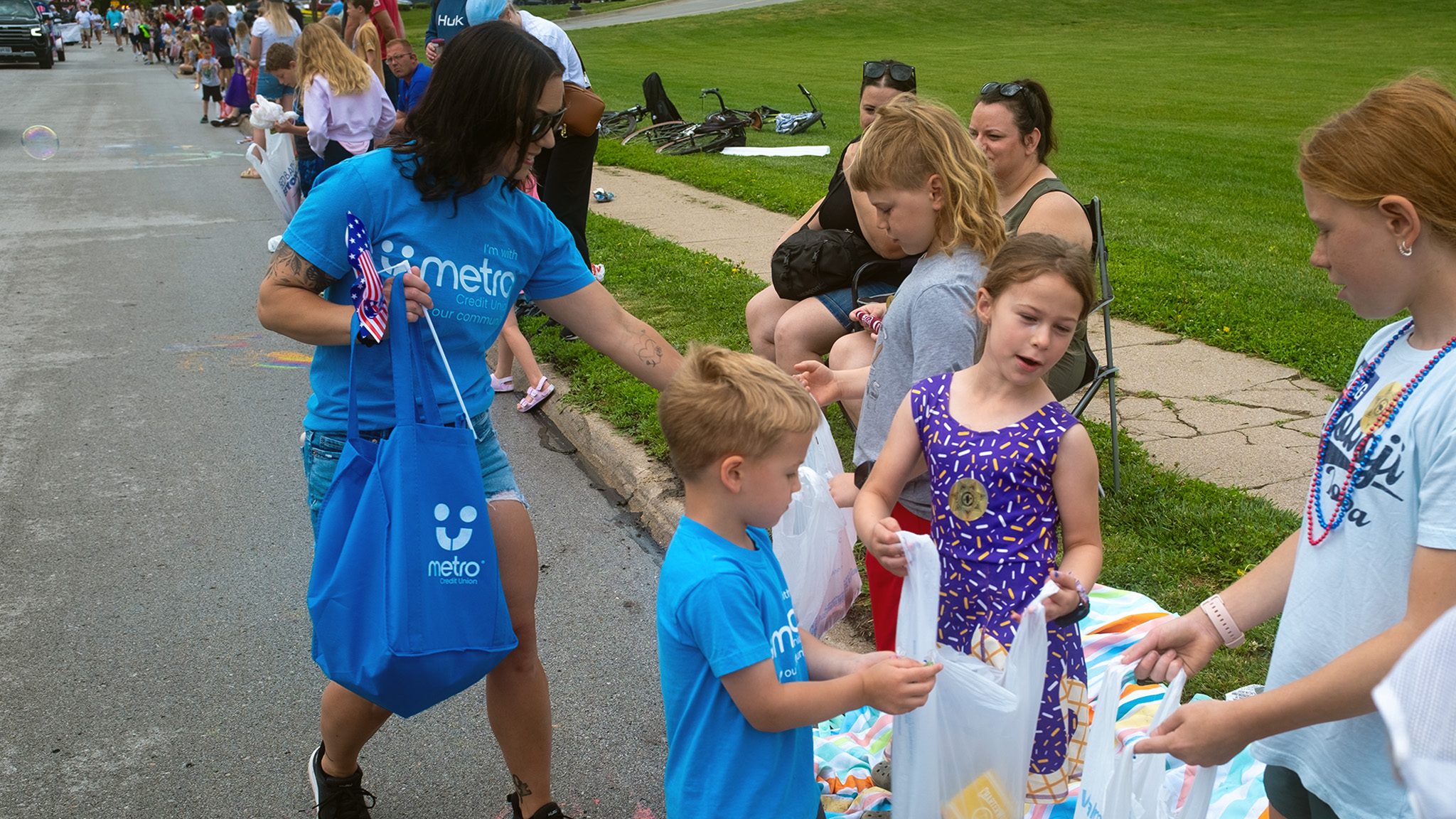 Metro employee and their child handing out candy at the Elkhorn Days parade